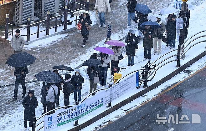 [수원=뉴시스] 김종택 기자 = 수도권 지역에 대설특보가 발효된 지난달 12일 경기도 수원시 영통구 망포역 인근에서 출근길 시민들이 내리는 눈을 맞으며 버스를 기다리고 있다. 2025.02.12. jtk@newsis.com