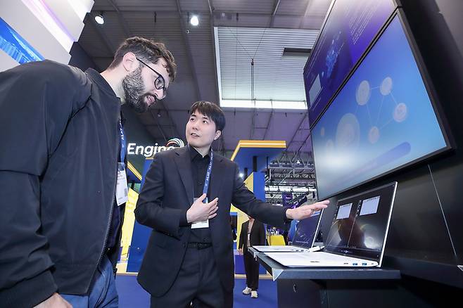 MWC25 KT 전시관 내 K-Lab 존에서 KT 전시요원이 KT의 네트워크 비전과 6G 핵심 기술을 소개하는 모습