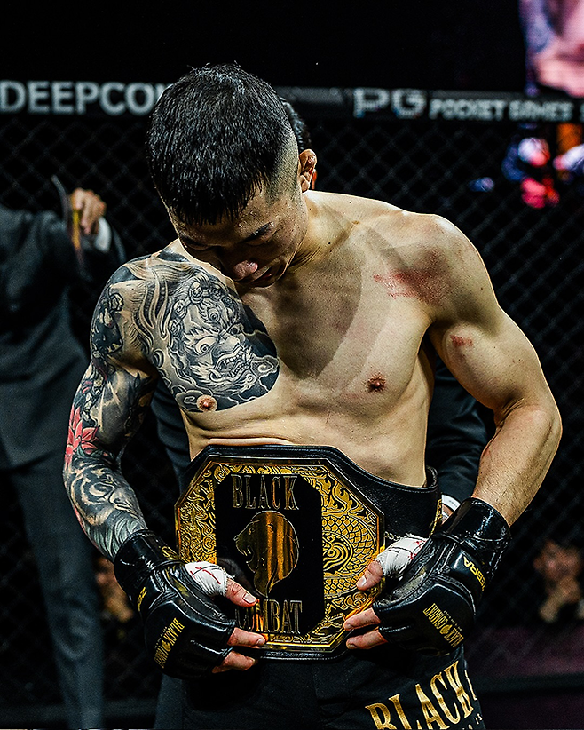 김재웅이 2024년 12월 서울특별시 고려대학교 화정체육관에서 제3대 블랙컴뱃 밴텀급 챔피언 벨트를 보며 감격하고 있다. 사진=이데아 파라곤