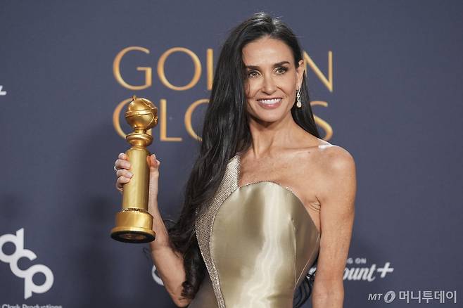 [베벌리힐스=AP/뉴시스] 배우 드미 무어가 5일(현지시각) 미 캘리포니아주 베벌리힐스의 더 베벌리 힐튼에서 열린 제82회 골든글로브 시상식에서 '더 서브스턴스'로 뮤지컬·코미디 부문 여우주연상을 받은 후 기자실에서 포즈를 취하고 있다. 무어는 생애 처음으로 골든글로브 여우주연상을 받았다. 2025.01.06. /사진=민경찬