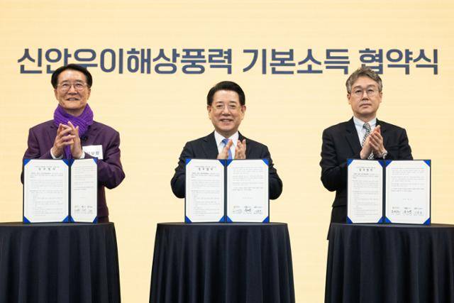 5일 오후 국회도서관 대강당에서 열린 '2025 미지답 전남 포럼'에서 김영록(가운데) 전남지사, 박우량(왼쪽) 신안군수, 이용안 신안우이해상풍력 대표이사가 기본소득협약서에 서명하고 있다. 이한호 기자