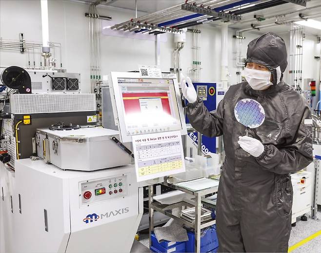 방진복을 입은 이혁재 서울대 반도체공동연구소장이 절연막 건식 식각기(ICP etcher)﻿에 대해 설명하고 있다. 이 장비는 실리콘 산화물이나 질화물을 식각할 때 쓰인다.  /임형택 기자