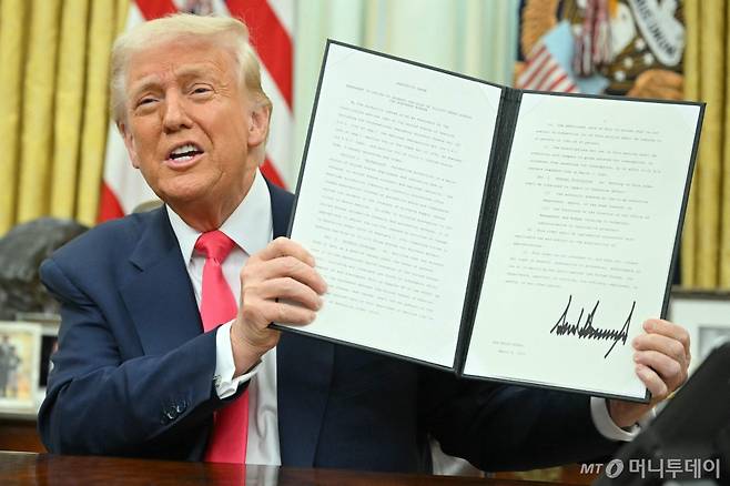 (워싱턴 AFP=뉴스1) 우동명 기자 = 도널드 트럼프 미국 대통령이 6일(현지시간) 워싱턴 백악관에서 멕시코와 캐나다에서 수입되는 제품 중 USMCA에 적용되는 품목에 대해서는 내달 2일까지 '25% 관세'를 면제하는 행정명령에 서명을 한 뒤 들어 보이고 있다. 2025.03.07  ⓒ AFP=뉴스1  Copyright (C) 뉴스1. All rights reserved. 무단 전재 및 재배포,  AI학습 이용 금지. /사진=(워싱턴 AFP=뉴스1) 우동명 기자