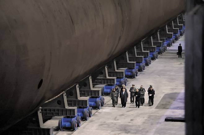 북한은 8일 김정은 국무위원장이 조선소를 찾아 건조 중인 ‘핵동력 전략유도탄 잠수함’을 시찰했다며 현장 사진을 공개했다. 북한이 공개한 사진을 보면 김정은은 건조 중인 잠수함 옆을 걸으며 참모들의 보고를 받고 있다. 김정은의 방문 시점과 장소는 공개하지 않았다./조선중앙통신 연합뉴스