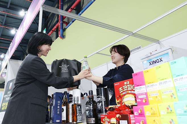 2025 대한민국주류대상 박람회 관람객이 입장을 앞두고 기념품을 수령하고 있다. /조선비즈