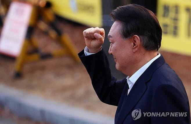 석방된 윤석열 대통령이 8일 경기도 의왕시 서울구치소 앞에서 경호 차량에서 내려 지지자들에게 인사하며 주먹을 불끈 쥐어 보이고 있다. 연합뉴스