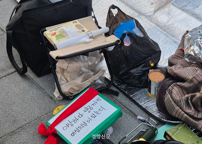 윤 대통령이 석방된 다음날인 9일 오전 6시20분쯤 서울 종로구 광화문 서십자각에 철야 집회에 나선 시민들의 응원봉·손팻말·간식 등이 놓여있다. 이예슬 기자