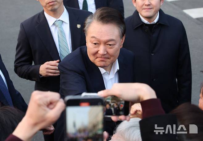 [서울=뉴시스] 김금보 기자 = 석방된 윤석열 대통령이 8일 오후 서울 용산구 한남동 관저 입구에서 지지자들에게 인사하고 있다. 2025.03.08. kgb@newsis.com