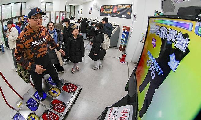 서울 동대문구 청량오락실에서 한 아버지가 펌프(Pump it up) 게임을 즐기는 동안 가족들이 춤을 감상하고 있다.