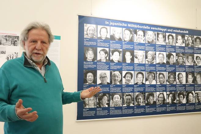 지난 6일 나치기록박물관에서 한겨레와 만난 ‘2차 세계대전 시기의 제3세계’ 전시기획자 카를 뢰셀. 그의 뒤로 일본군 ‘위안부’ 피해 여성 44명의 사진과 이름이 담긴 걸개막이 걸려 있다.