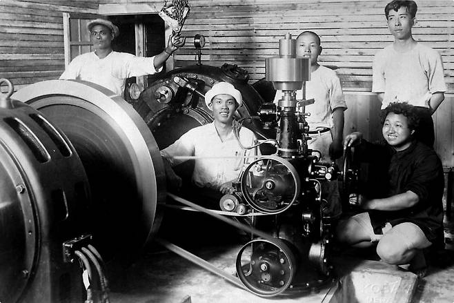 100년전쯤 호시노 2세(가운데)가 수력발전기를 발명한뒤 기념촬영을 하고 있다.