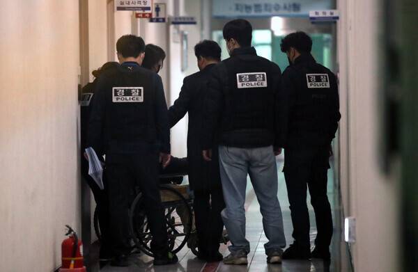 대전 초등생 살해교사 명모씨가 지난 7일 대전서부경찰서에서 대면조사를 마친 뒤 조사실을 나오자, 경찰들이 외부에 모습이 보이지 않도록 가리고 있다. 연합뉴스