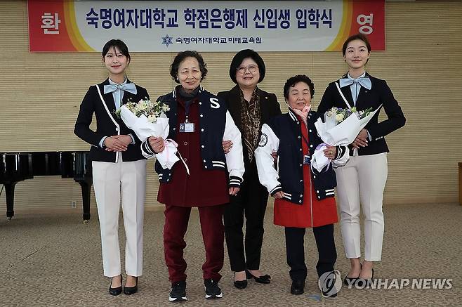 입학 축하 (서울=연합뉴스) 서명곤 기자 = 10일 서울 용산구 숙명여자대학교 백주년기념관에서 열린 미래교육원 입학식에서 문시연 총장이 학업에 도전하는 새내기 김갑녀(87), 모부덕(87) 할머니에게 학교 점퍼를 입혀준 뒤 기념촬영을 하고 있다. 2025.3.10 seephoto@yna.co.kr