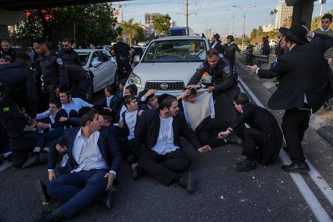 지난 2일 이스라엘 브네이브라크의 한 도로에서 경찰이 징집 반대 시위를 벌이는 초정통파 청년들을 제지하고 있다./AP 연합뉴스