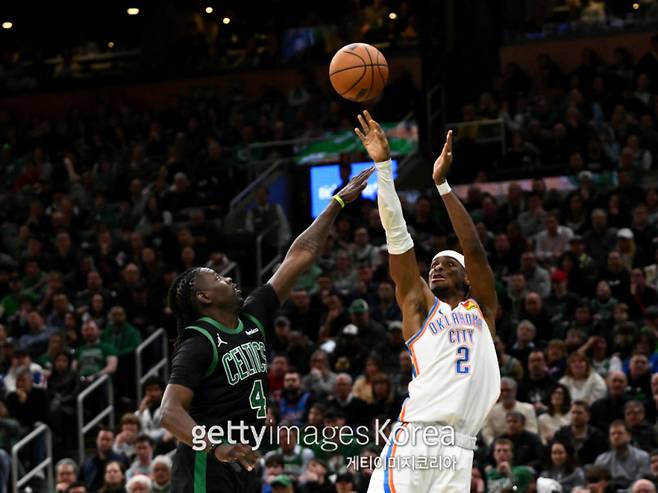오클라호마 길저스-알렉산더(오른쪽)가 13일 TD 가든에서 열린 보스턴과의 2024~25 NBA 정규리그 원정 경기 중 보스턴 할러데이 앞에서 3점슛을 시도하고 있다. 사진=게티이미지