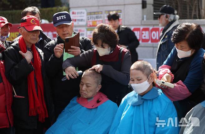 [서울=뉴시스] 김선웅 기자 = 헌재의 윤석열 대통령에 대한 탄핵심판 선고가 임박한 13일 서울 종로구 헌법재판소 앞에서 친 윤 성향 시민들이 탄핵을 반대하며 삭발을 하고 있다. 2025.03.13. mangusta@newsis.com