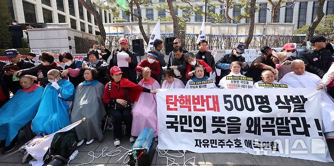 [서울=뉴시스] 김선웅 기자 = 헌재의 윤석열 대통령에 대한 탄핵심판 선고가 임박한 13일 서울 종로구 헌법재판소 앞에서 친 윤 성향 시민들이 탄핵을 반대하며 삭발을 하고 있다. 2025.03.13. mangusta@newsis.com