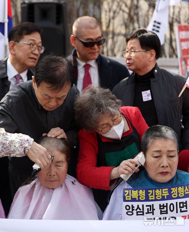 [서울=뉴시스] 김선웅 기자 = 헌재의 윤석열 대통령에 대한 탄핵심판 선고가 임박한 13일 서울 종로구 헌법재판소 앞에서 친 윤 성향 시민들이 탄핵을 반대하며 삭발을 하고 있다. 2025.03.13. mangusta@newsis.com
