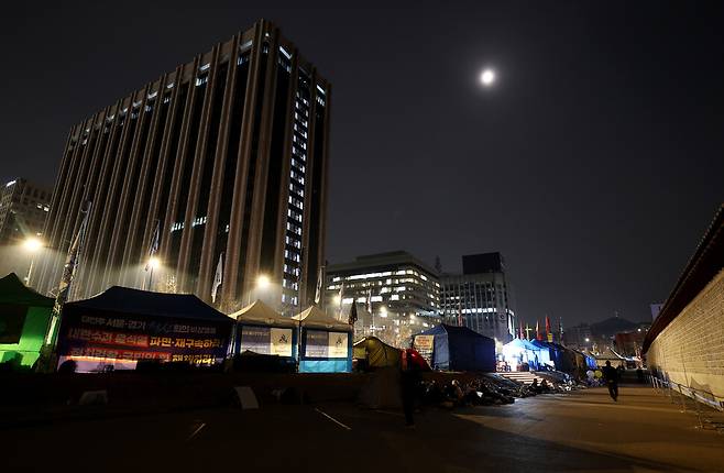 ‘윤석열즉각퇴진·사회대개혁 비상행동’이 닷새째 즉각 파면을 촉구하며 단식 농성을 벌인 3월12일 새벽 서울 종로구 광화문 앞 모습. 달이 떠 있다.