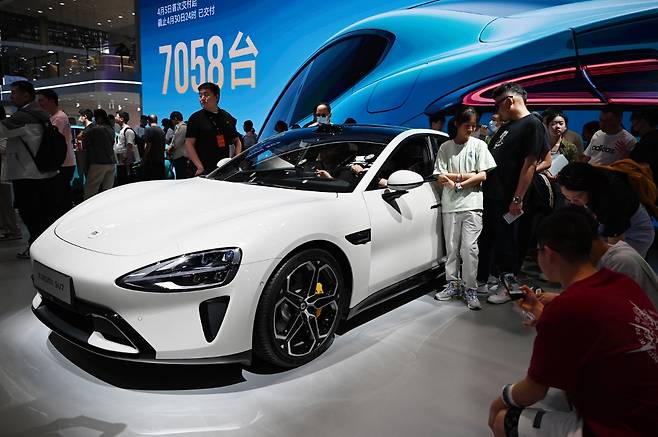 지난해 5월 베이징 오토쇼에서 관람객들이 샤오미 전기차 SU7을 구경하고 있다./AFPBBNews=뉴스1