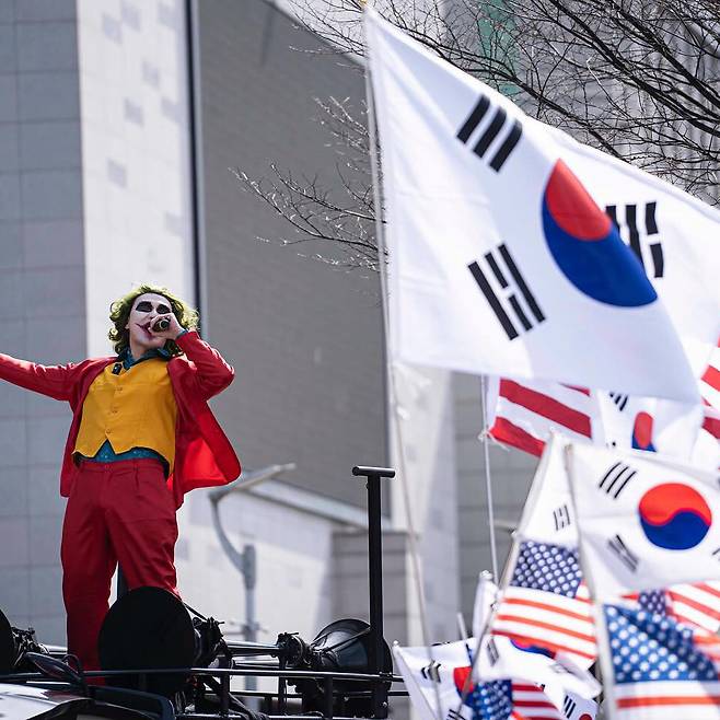 미국 영화 ‘조커’의 주인공 광대로 분장한 한 극우 유투버와 윤석열 대통령 지지자들이 지난 3일 오후 서울 동작구 중앙대 정문 앞에서 탄핵 촉구 기자회견 중인 학생들을 향해 차량 위에 올라 마이크를 잡고 소리치고 있다. 12·3 계엄 사태는 한국의 극우세력이 반민주적 폭력성을 거침없이 드러내는 계기가 됐다. ⓒ사진가 박민석 제공