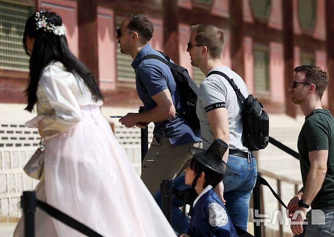 [서울=뉴시스] 홍효식 기자 = 서울 낮 최고기온이 18도까지 오르며 완연한 봄 날씨를 보인 14일 서울 종로구 경복궁을 찾은 외국인 관광객들이 반팔 티셔츠를 입고 관람하고 있다. 2025.03.14. yesphoto@newsis.com