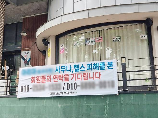 헬스장이 문을 닫자 옥현씨는 사비를 털어 피해자들을 모아 대책을 강구했다. 사진은 옥현씨가 설치한 현수막.[사진 | 더스쿠프 포토]