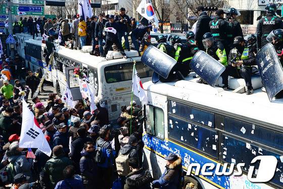 헌법재판관 만장일치로 박근혜 전 대통령의 탄핵이 인용되자 서울 종로구 안국역 주변에서 열린 태극기 집회에 모인 시민들이 헌법재판소 앞을 지키는 경찰들과 충돌 하고 있다. 박2017.3.10/뉴스1 ⓒ News1 임세영 기자