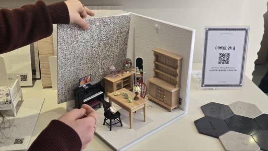 LX하우시스가 서울 북촌 위크앨리에 연출한 체험형 팝업 전시관 '트렌드십 2025'의 벽지와 바닥재 샘플이 진열된 전시관 2층 미니어처 체험 공간. 관람객이 16일 현장에서 직접 자재를 만지고 조합해보며 공간을 입히는 경험을 하고 있다.