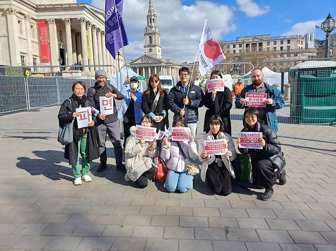 15일(현지시각) 영국 런던 내셔널 갤러리 앞에서는 ‘제8차 재영한인촛불집회’가 열렸다. 교민들은 윤석열 대통령에 대한 “석방은 무죄의 동의어가 아니”라며 헌법재판소를 향해 “조속히 탄핵을 인용해 윤석열을 즉각 파면하라”고 외쳤다. ‘민주묘(고양이)총 런던본부’, ‘정오의 태양 아래 깃발을 드는 연합’ 등 재치있는 문구가 적힌 깃발을 직접 만들어 현장에 갖고 온 교민들도 있었다. 사진 영국 교민 제공