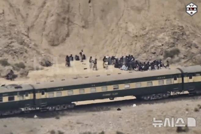 [퀘타=AP/뉴시스] 지난 11일(현지 시간) 파키스탄 남서부 발루치스탄주에서 반군인 발루치스탄해방군(BLA)에 납치돼 멈춘 열차 밖에 일부 승객들이 나와 있다. 2025.03.13.