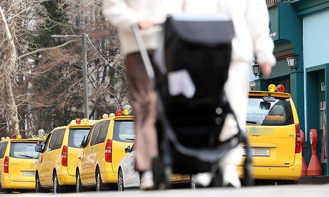 서울 강남구 한 영어유치원에 주차된 통학버스 앞으로 유모차를 끌고 지나가는 시민 모습. 연합뉴스