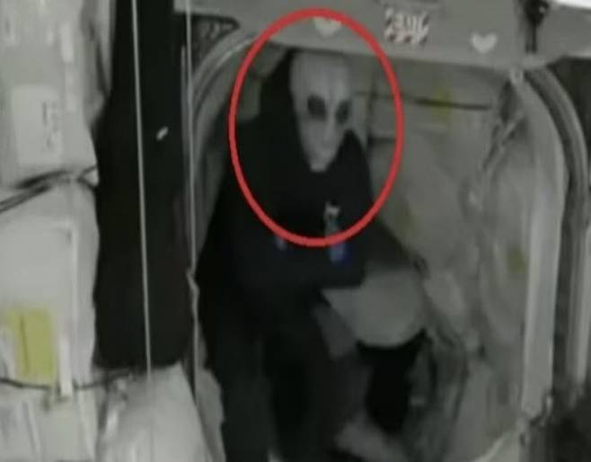 ‘크루-9’ 지휘관 닉 헤이그가 외계인 가면을 쓴 채 ‘크루-10’ 대원들을 맞이할 준비를 하고 있다. 사진=미 항공우주국(NASA) 생중계 캡처