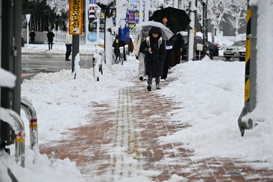 강원 동해안과 산지를 중심으로 많은 눈이 내린 17일 강원 속초시에서 학생들이 등교하고 있다. 속초시 제공