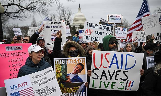 도널드 트럼프 미국 행정부의 국제개발처(USAID) 프로그램 폐지 조치에 반대하는 사람들이 워싱턴에서 피켓 시위를 벌이고 있다. 워싱턴=AP연합뉴스