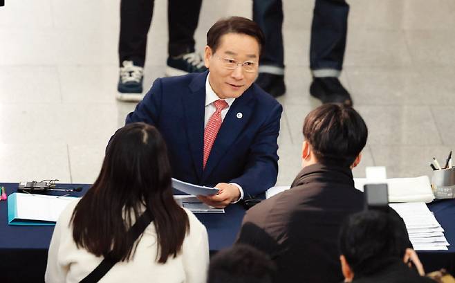 유정복 인천시장이 3월 6일 인천시청 중앙홀에 마련된 ‘천원주택’ 접수처에서 예비 입주자들의 신청서를 받으며 대화를 나누고 있다. [뉴시스]