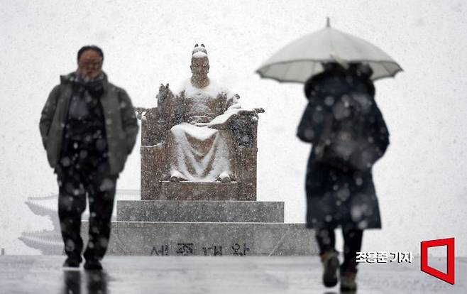 서울 역대 가장 늦은 대설특보가 발효된 18일 서울 종로 광화문광장에서 시민들이 눈을 맞으며 출근길을 서두르고 있다. 2025.3.18 조용준 기자