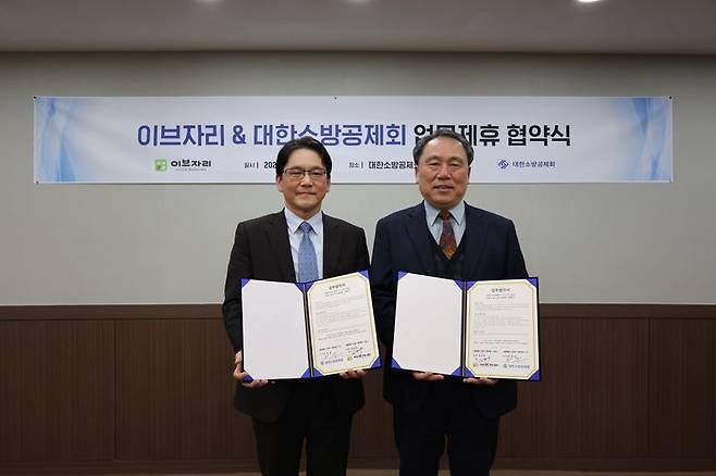 지난 14일 고정욱 이브자리 비전티움 대표(왼쪽)와 이일 대한소방공제회 이사장(오른쪽)이 대한소방공제회 대회의실에서 업무협약을 맺고 기념촬영을 하고 있다. 이브자리 제공