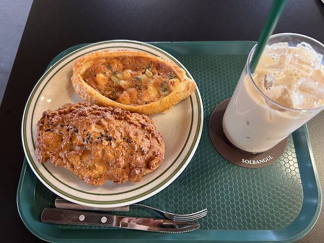The rice bread (bottom), pollack roe baguette and milk tea are served at Solbangul Bakery in Seosulla-gil, Jongno-gu, central Seoul (Park Jun-hee/The Korea Herald).