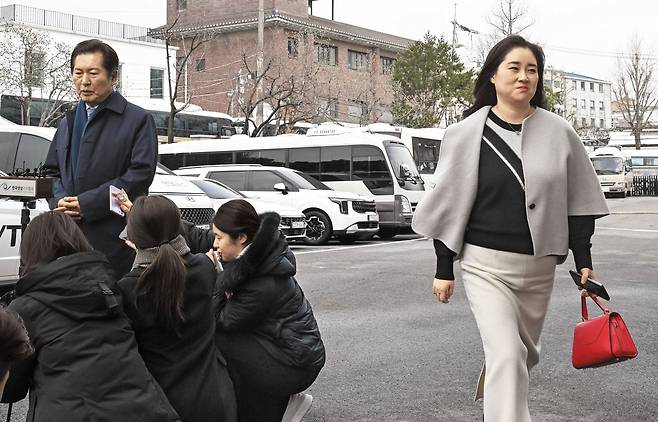 회견하는 정청래… 웃으며 지나친 김계리 - 18일 박성재 법무부 장관 탄핵 심판 첫 변론을 앞두고 서울 종로구 헌법재판소 앞에서 국회 탄핵소추위원장인 정청래(왼쪽) 더불어민주당 의원이 취재진에게 입장을 밝히는 가운데, 박 장관 재판에 방청 온 김계리 변호사가 웃으며 그 옆을 지나가고 있다. /고운호 기자