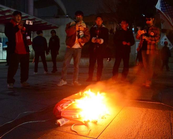 [청주=뉴시스] 서주영 기자 = 11일 충북대학교에서 보수 성향 유튜버와 시민들이 탄핵 찬성 집회 측이 현장에 놓고간 현수막을 불태우고 있다. 2025.03.11. juyeong@newsis.com /사진=뉴시스