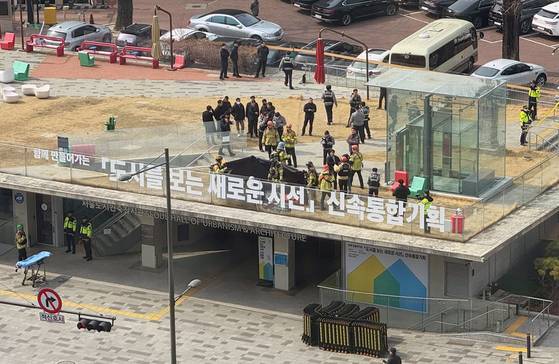 지난 7일 서울 중구 도시건축전시관 옥상에서 소방관들이 윤석열 대통령 지지자로 추정되는 한 남성의 분신 시도 현장을 수습하고 있다. 연합뉴스