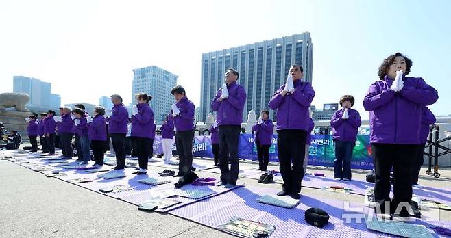 [서울=뉴시스] 고범준 기자 = 10.29 이태원 참사 유가족협의회, 시민대책회의 관계자들이 19일 서울 종로구 광화문 월대 옆에서 윤석열 대통령 파면 기원 159배를 하고 있다. 2025.03.19. bjko@newsis.com