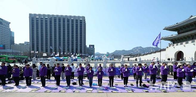 [서울=뉴시스] 고범준 기자 = 10.29 이태원 참사 유가족협의회, 시민대책회의 관계자들이 19일 서울 종로구 광화문 월대 옆에서 윤석열 대통령 파면 기원 159배를 하고 있다. 2025.03.19. bjko@newsis.com