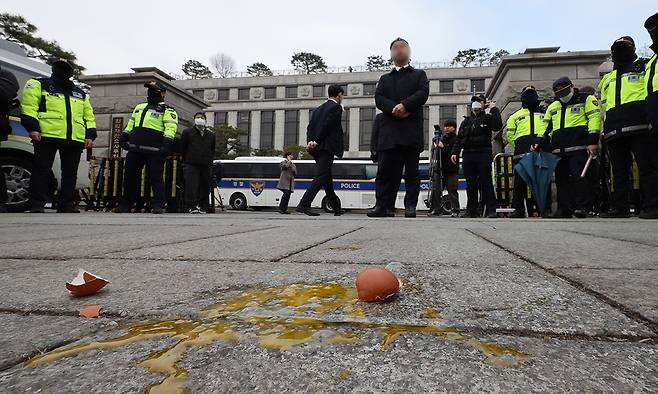 20일 서울 종로구 헌법재판소 앞에 보수단체 회원이 기자회견을 하던 더불어민주당 원내부대표단에게 던진&nbsp;계란이 바닥에 떨어져 있다. 연합뉴스