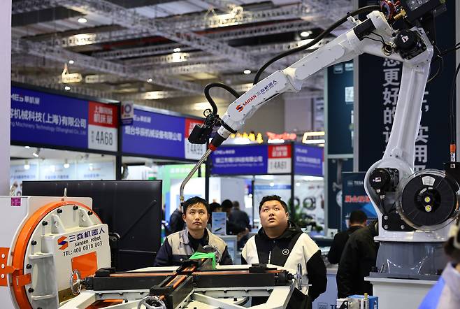 지난 3일 중국 상하이에서 개막한 '2025 상하이 글로벌 공작기계 전시회'에서 관람객들이 로봇 시연을 지켜보고 있다. 이번 전시회에는 국내외 1200여 곳의 기업이 참여해 전기차, 전자장비, 항공장비 등 첨단 산업 맞춤형 제조 솔루션을 선보였다./신화 연합뉴스