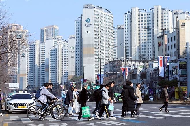 지난 20일 서울 송파구 잠실 트리지움 아파트 앞을 시민들이 지나고 있다.  /최혁 기자