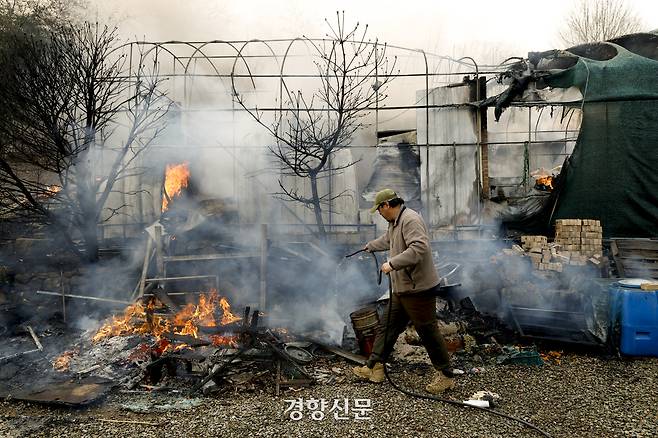 22일 경남 산청군 시천면 산불 현장에서 한 주민이 자택으로 번진 불을 막기 위해 애를 쓰고 있다. 문재원 기자