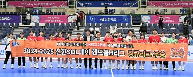 2024-2025 핸드볼 H리그 여자부서 조기에 정규리그 우승을 확정한 광명 SK 슈가글라이더즈의 박종혁 단장(가운데 오른쪽)과 김경진 감독(가운데 왼쪽)을 비롯한 선수단이 플래카드를 펼쳐들고 있다.한국핸드볼연맹 제공