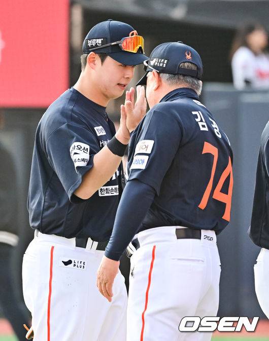 [OSEN=수원, 박준형 기자] 한화 김경문호가 무서운 뒷심을 앞세워 2025시즌 개막전을 승리로 장식했다. '50억 원 FA' 심우준이 친정팀을 상대로 날린 2루타가&nbsp;결승타로 기록됐다.프로야구 한화 이글스는 22일 수원KT위즈파크에서 펼쳐진 2025 신한 SOL뱅크 KBO리그 KT 위즈와의 개막전에서 4-3으로 승리했다.&nbsp;경기종료 후 한화 노시환이 김경문 감독과 하이파이브를 하고 있다. 2025.03.22 / soul1014@osen.co.kr